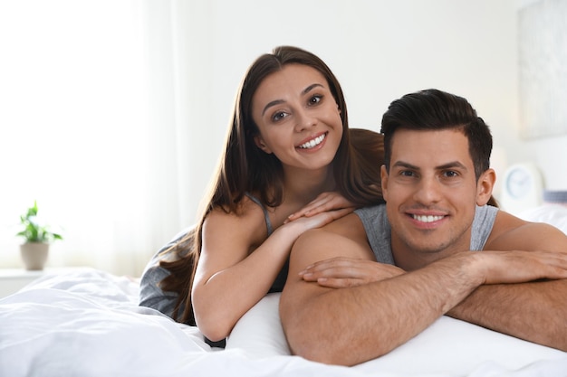 Portrait of lovely couple resting on large bed
