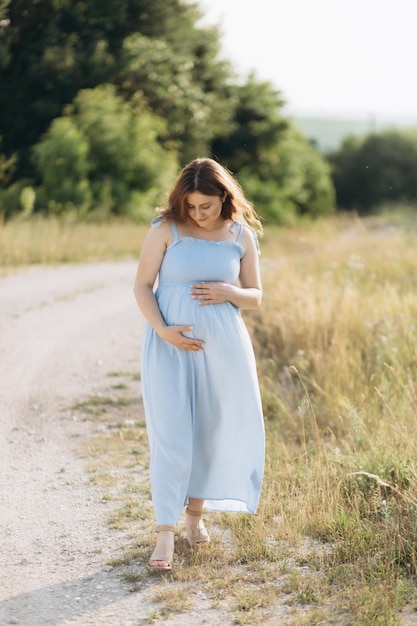 Portrait of a lovely couple standing together on the greenfield Happy couple expecting a baby young family concept