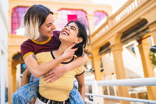 Portrait of lovely lesbian couple spending time together and having fun at the street.