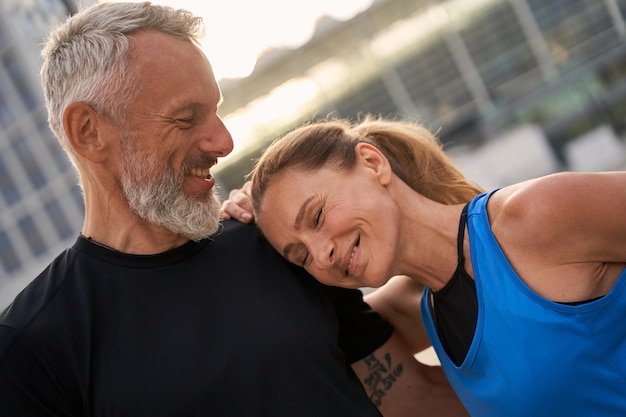 Portrait of lovely middle aged couple man and woman in sportswear having morning workout in the