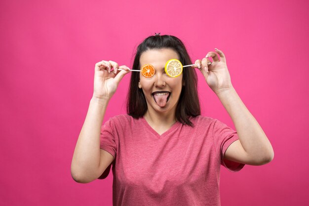 Portrait of lovely sweet beautiful cheerful woman with straight brown hair holding a lollipop