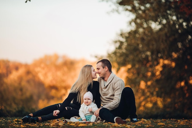 Portrait of lovely young family sitting together outside