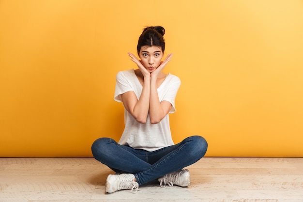 Portrait of a lovely young woman sitting with legs crossed