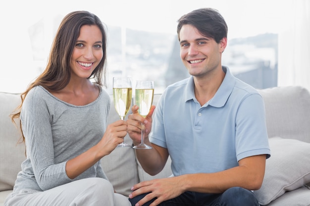 Portrait of lovers clinking their flutes of champagne