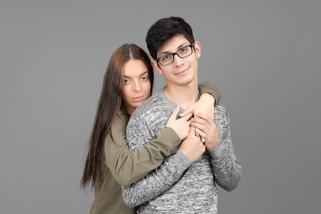 Portrait of loving couple in studio girl hugging latin boy