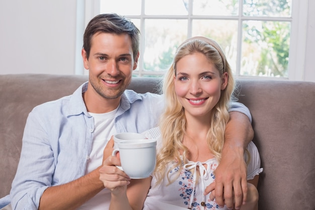 Portrait of a loving couple with coffee cups in living room