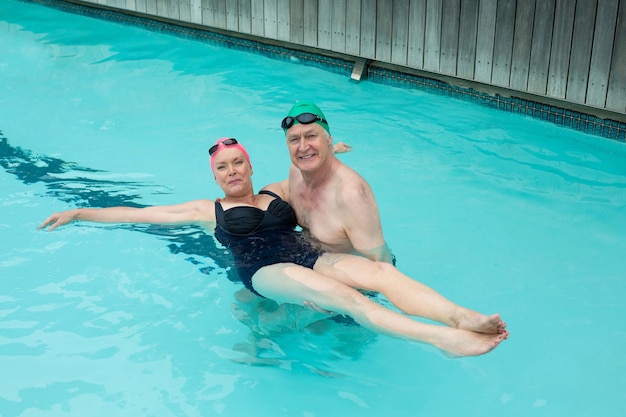 Portrait of loving mature couple enjoying in swimming pool