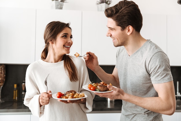 Photo portrait of a loving young couple holding dinner plates