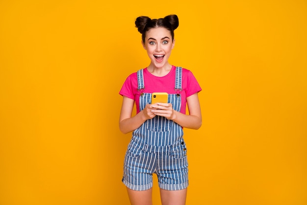 Portrait of lucky cheerful girl using cell having fun celebrating success 