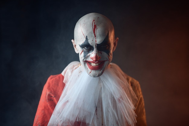 Portrait of mad bloody clown, face in blood