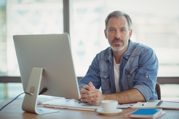 Portrait of male business executive sitting at desk