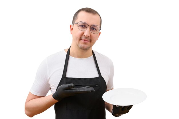 Portrait of a male chef in an apron with a plate in his hand on a white background Cooking concept