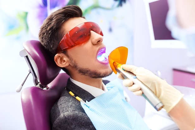 男性の歯科医療の概念の肖像画。歯科医に囲まれた男性に歯科検査が行われています。