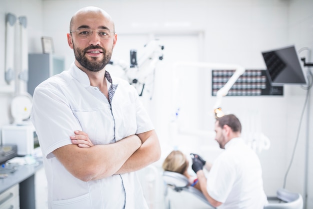 Foto ritratto di un dentista maschio con le mani piegate