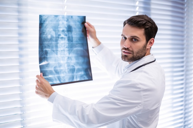 Portrait of male doctor examining x-ray