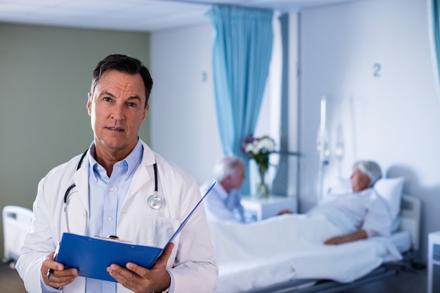 Portrait of male doctor holding a medical report