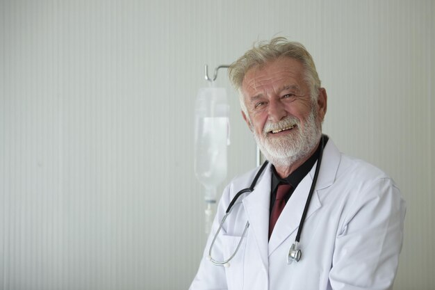 Photo portrait of male doctor smiling against wall