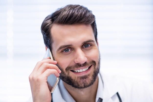 Portrait of male doctor talking on mobile phone