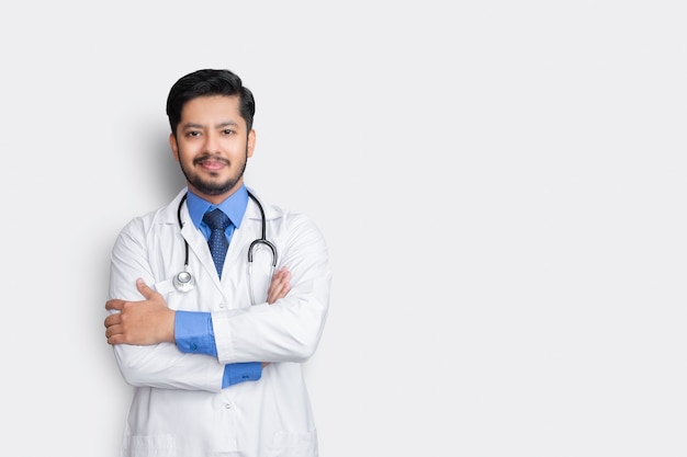 Photo portrait of male doctor with stethoscope and arm cross isolated on white wall. health insurance concept.