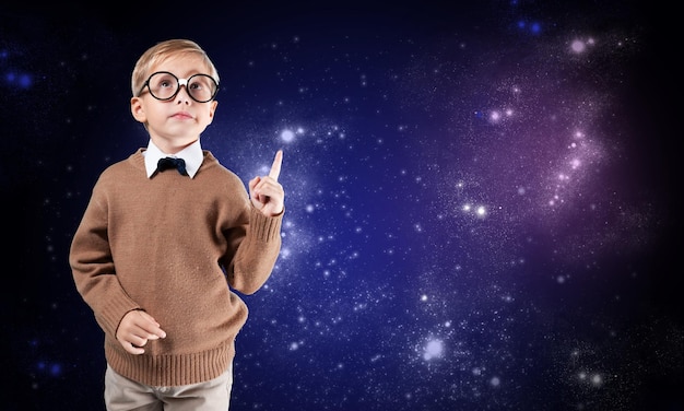 Portrait of male elementary school student with lightbulb picture on blackboard