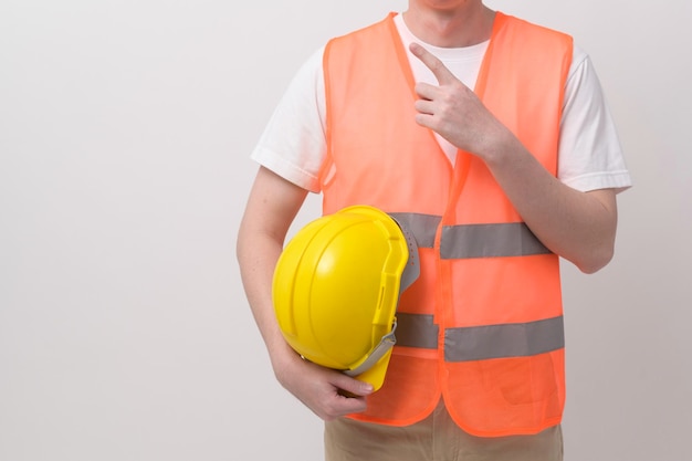 Ritratto di ingegnere maschio che indossa un casco protettivo su sfondo bianco studio