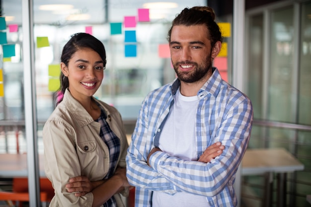 Portrait of male and female executives standing with arms crossed