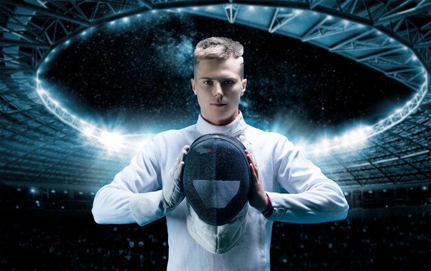 Portrait of a male fencer on the background of a sports arena