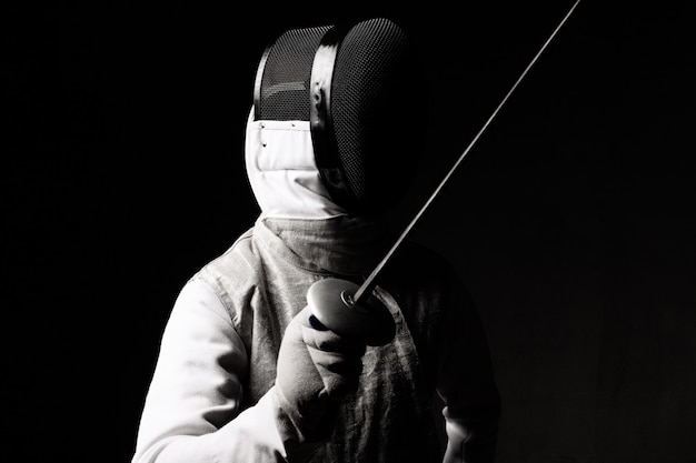 Photo portrait of male fencer in mask and foil performing fight