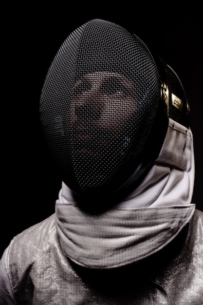 Portrait of male fencer in mask and foil performing fight 