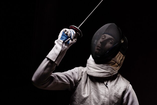 Photo portrait of male fencer in mask and foil performing fight