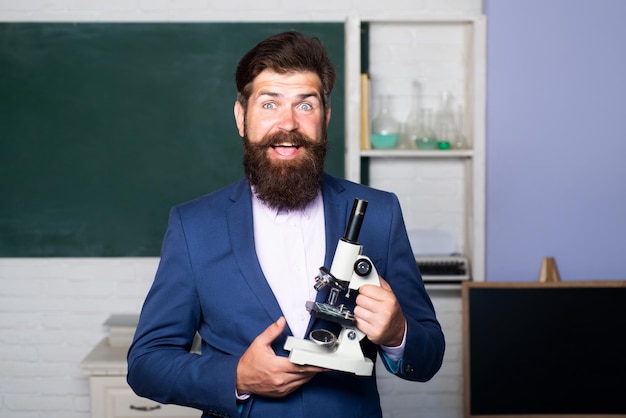 Portrait of a male friendly teacher in a classroom.