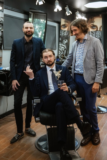 Portrait of a male groom in a blue suit in the morning barbershop