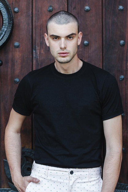 Photo portrait of male model standing against wooden door