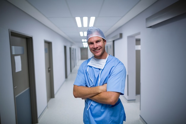 Portrait of male nurse standing in corridor