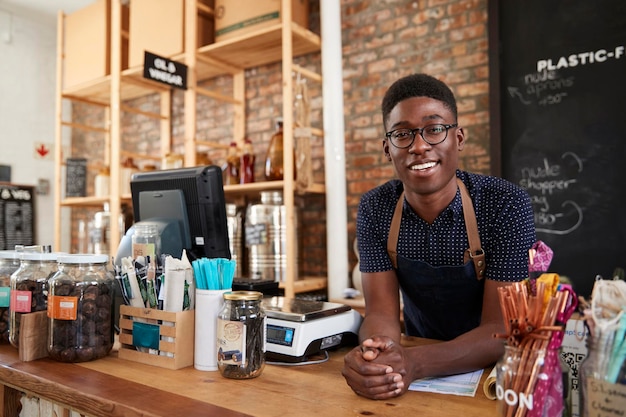 Portrait Of Male Owner Of Sustainable Plastic Free Grocery Store Behind Sales Desk