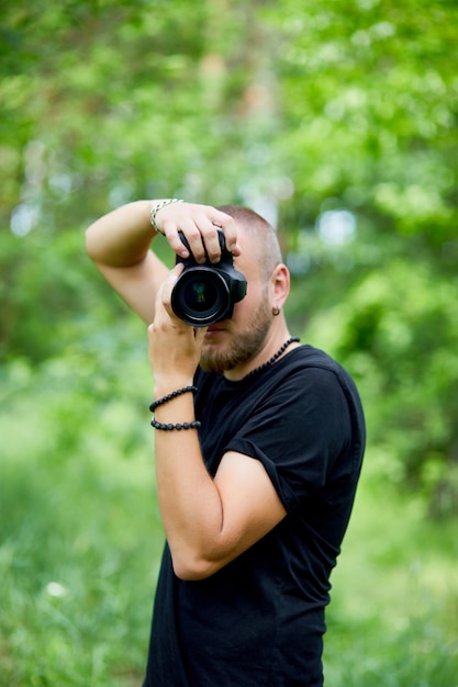 Portrait of a male photographer covering his face with the camera