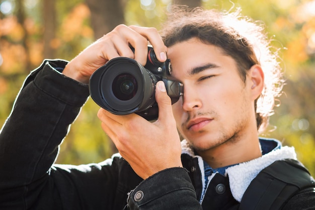 屋外で撮影する男性写真家の肖像画