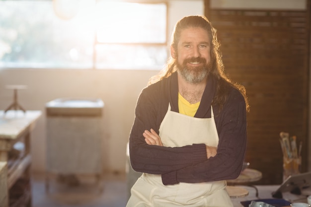 Portrait of male potter sitting on table