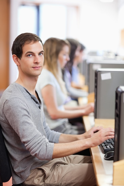 Portrait of a male student posing with a computer