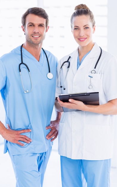 Portrait of a male surgeon and female doctor with medical reports at the hospital