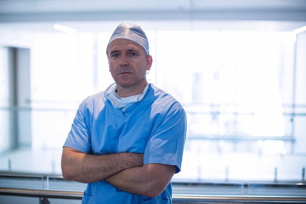 Portrait of male surgeon standing with arms crossed