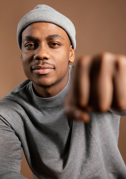 Portrait male wearing cap showing fist