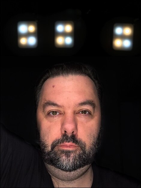 Portrait of man against black background