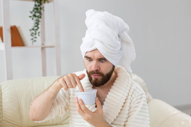 Portrait of man applying effective cream on his facial skin spa at home body and skin care for male