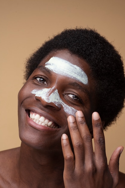 Photo portrait of a man applying moisturizer on his face