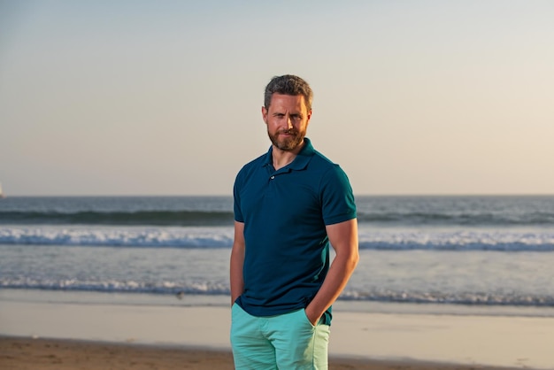 Portrait of man on beach. Portrait of middle aged man with a serious expression and ocean backdrop standing at the beach.