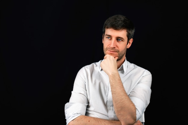 Portrait of a man on a black background. A businessman is planning a job. 