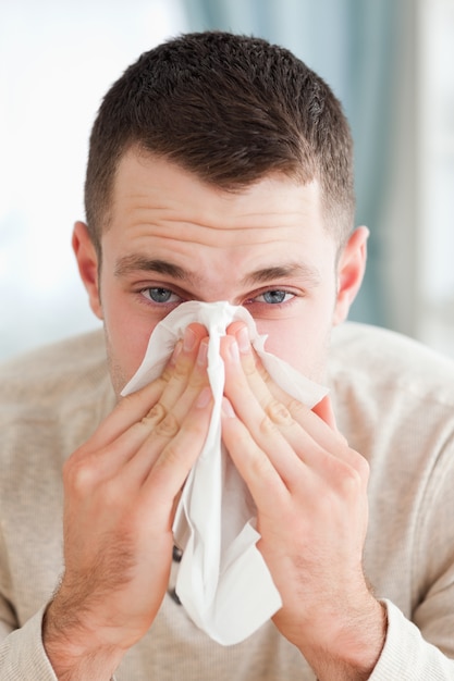 portrait of a man blowing his nose