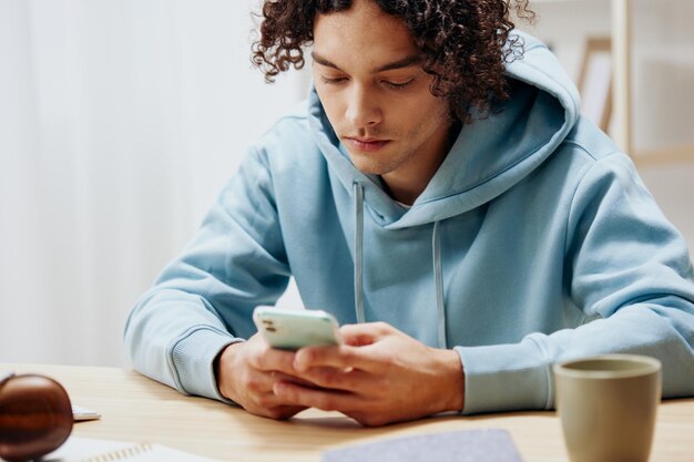 Portrait of a man in a blue jacket in front of a computer with\
phone interior