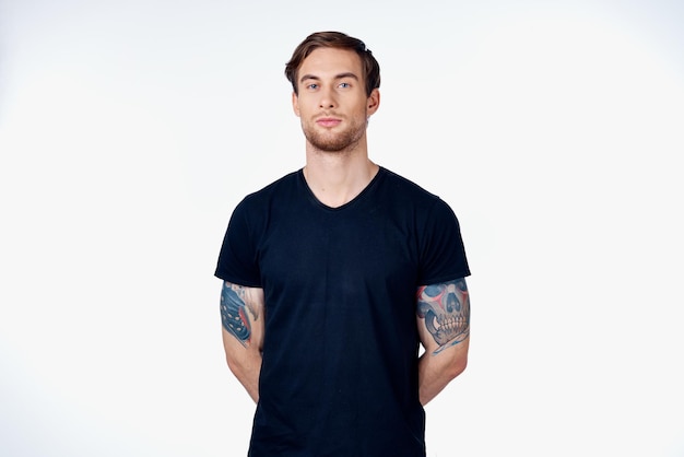 Portrait of a man in a blue tshirt with a tattoo on his arm blonde hair gray background High quality photo